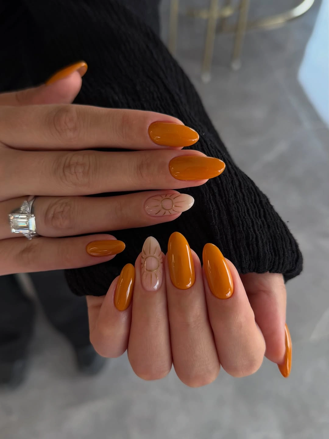 Glossy pumpkin orange almond nails with a pale line accent
