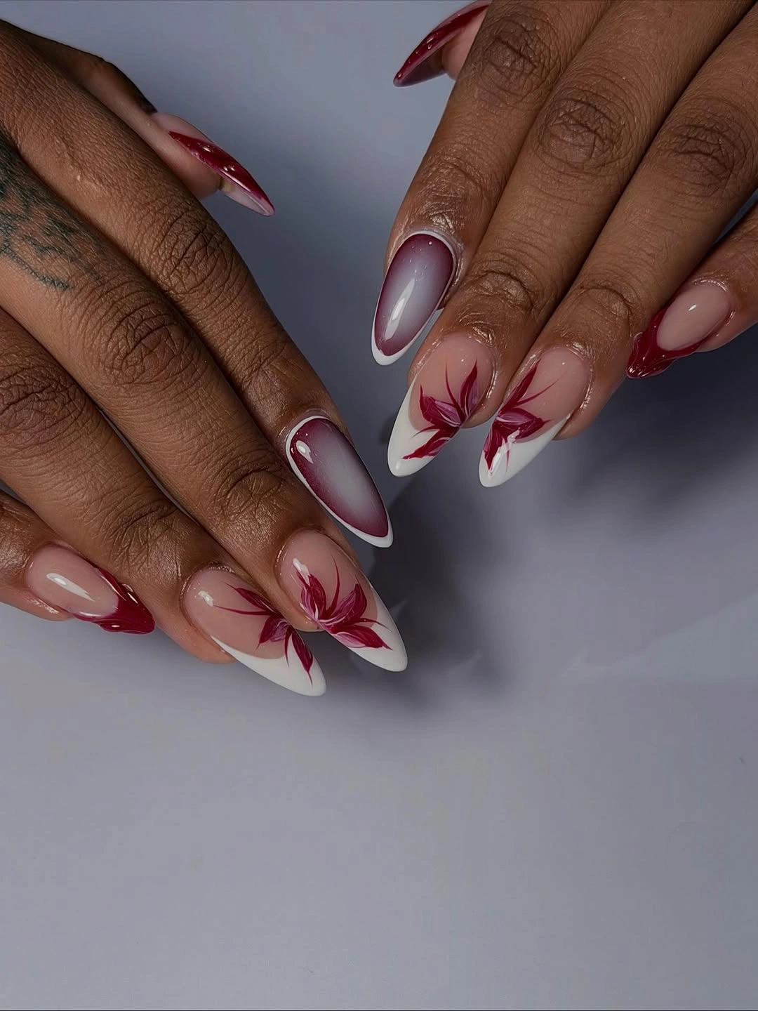 Berry almond nails with pale red floral line accents