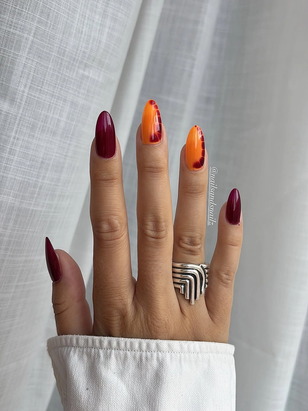 Dark berry almond nails with bright orange flame accents