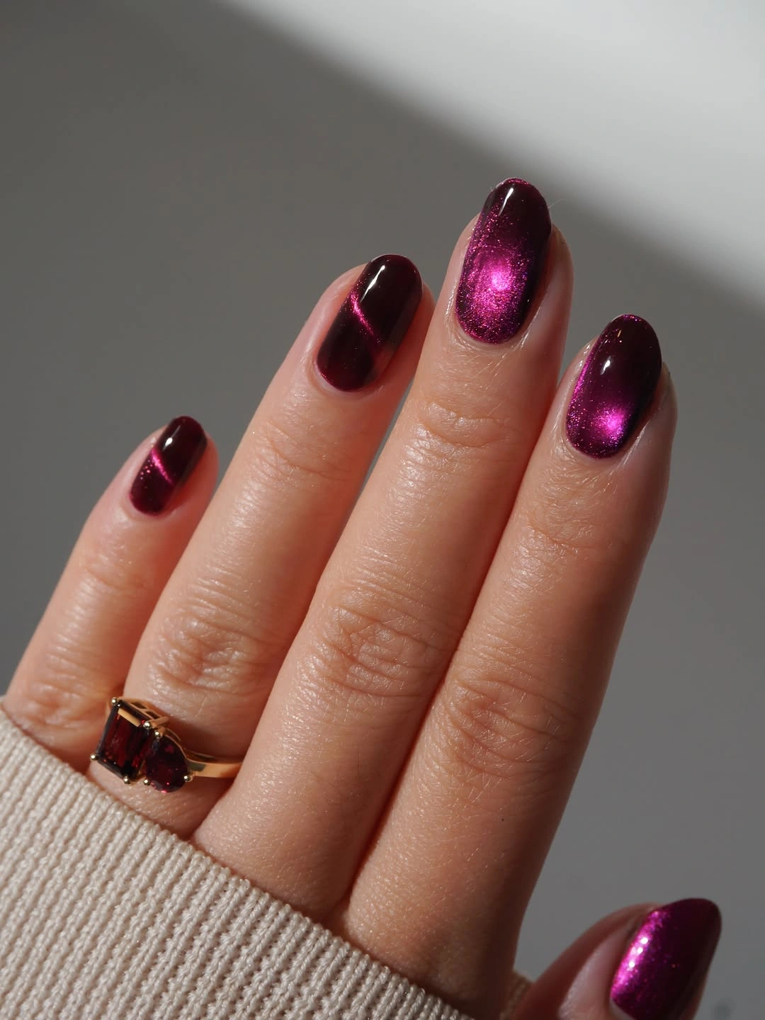 Glossy burgundy nails with one bright magenta shimmer accent