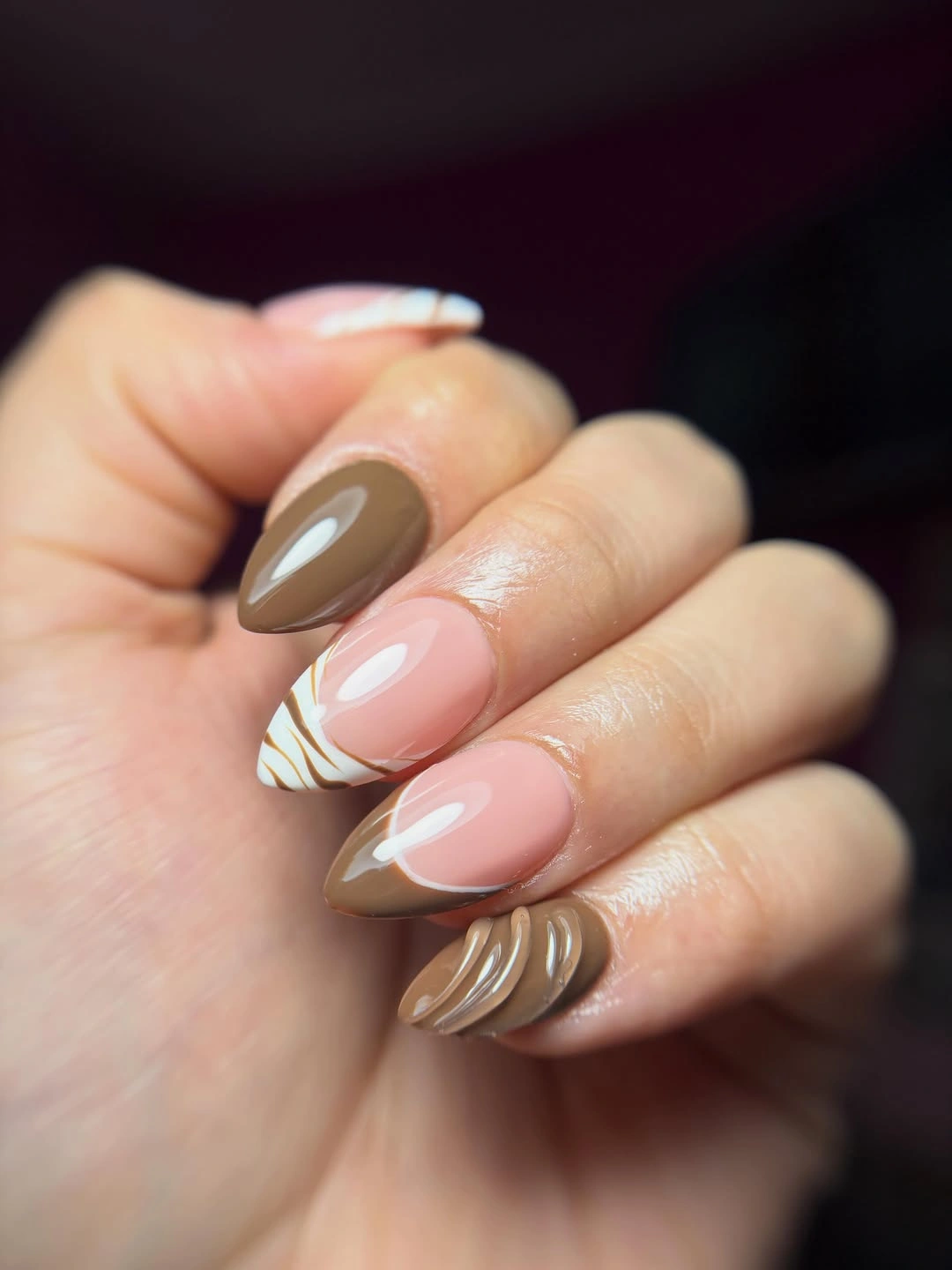 Short rounded nails in chocolate pink and flowing cream stripes