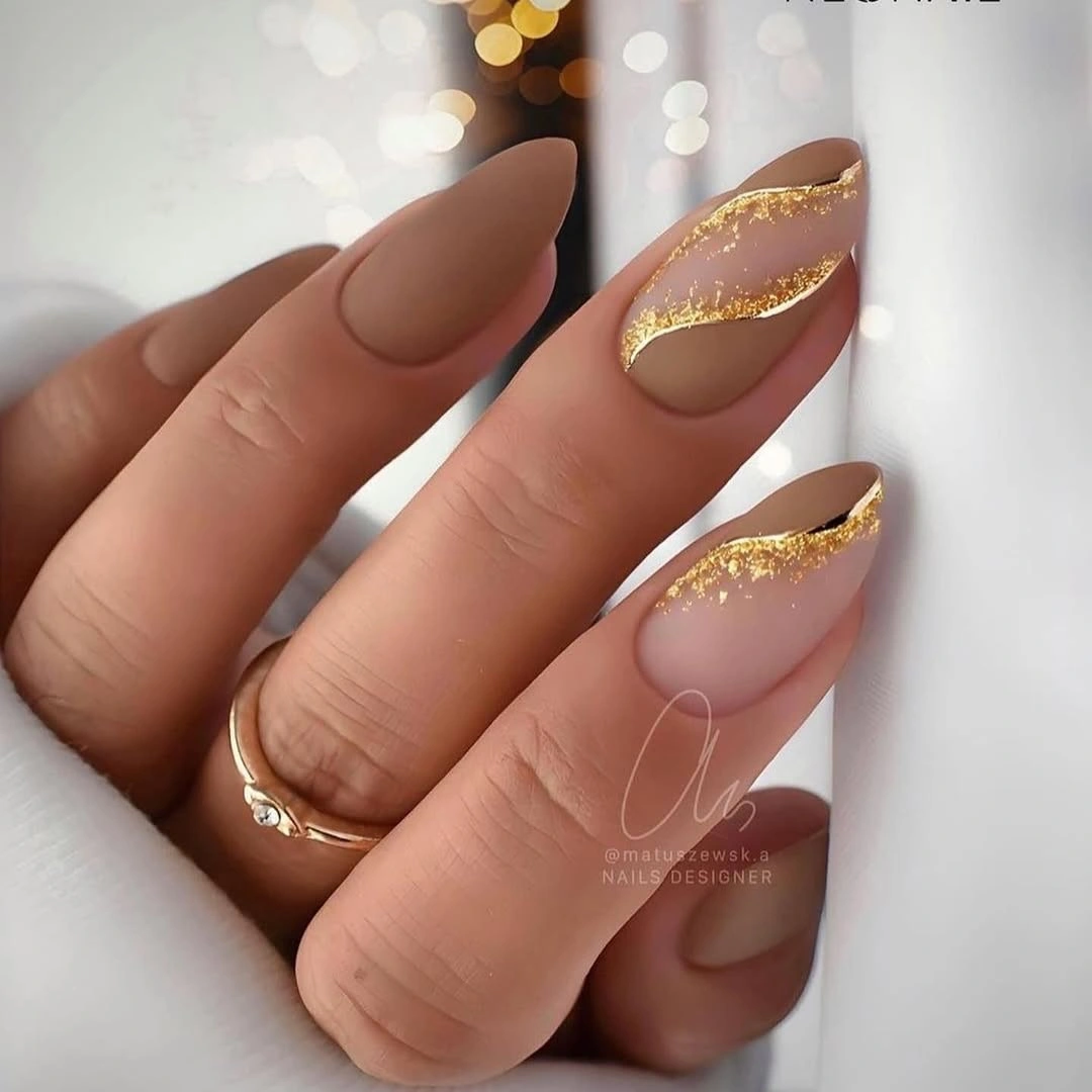 Blush almond nails with sweeping organic gold edge details