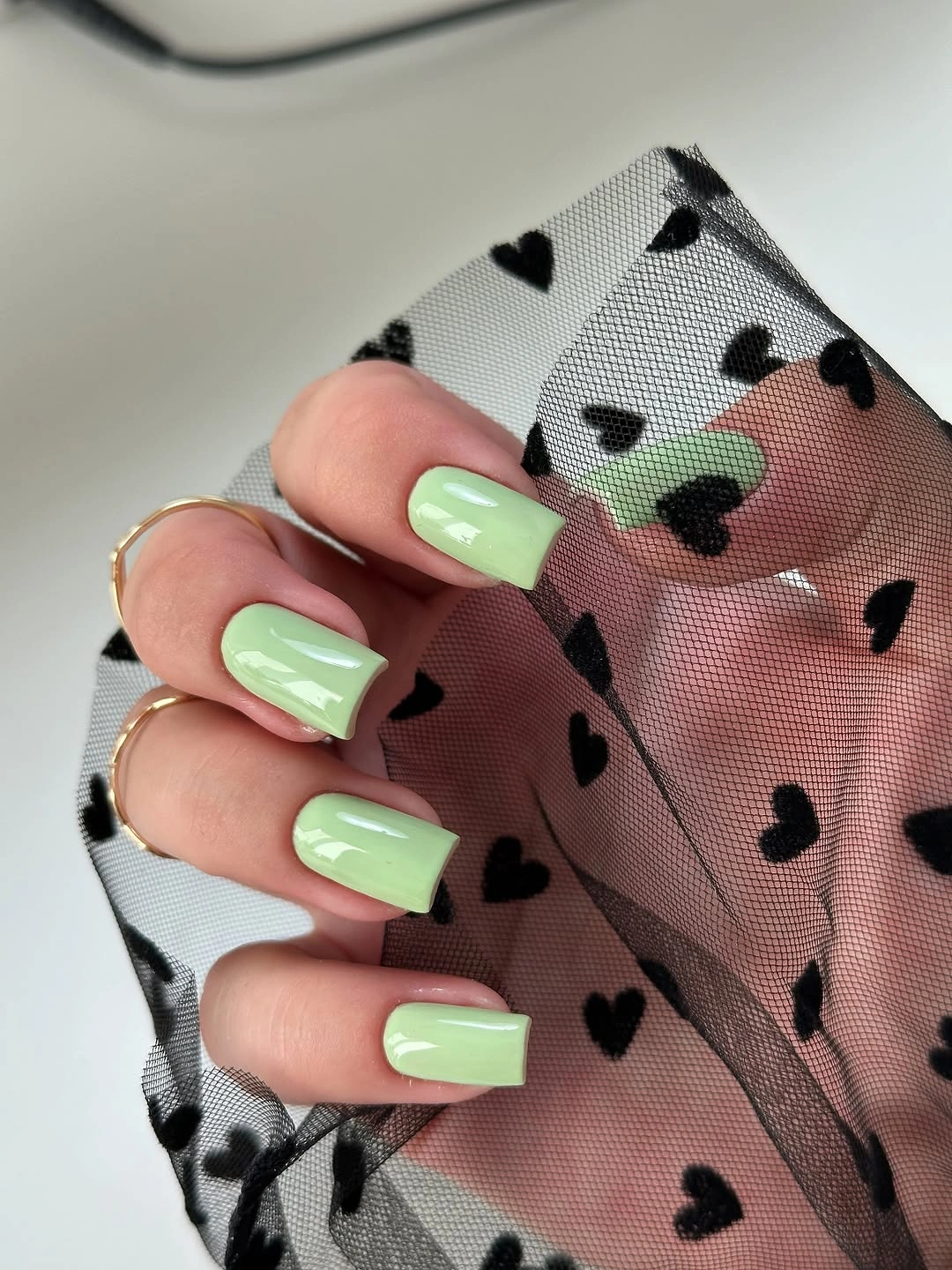 Pale mint square nails with small black heart accents