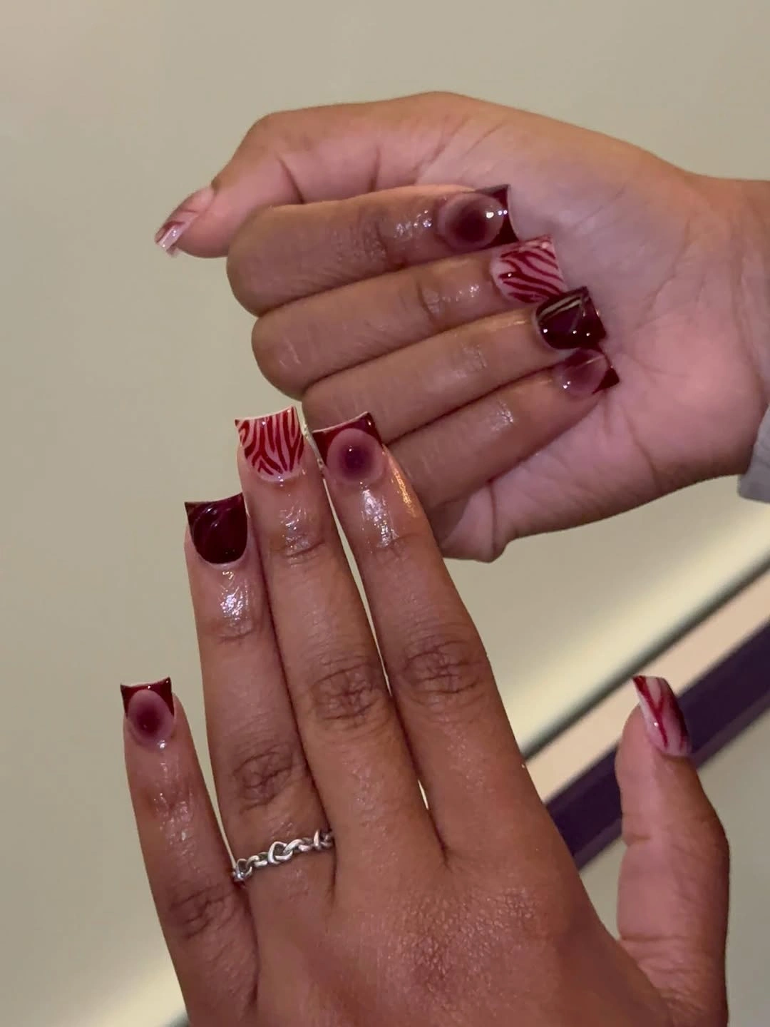 Sheer almond nails with deep wine French tips and fine accents