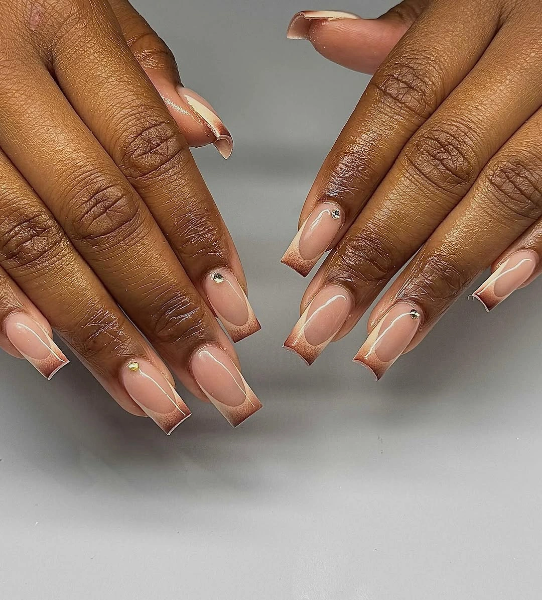 Pale almond nails with slim white and bronze gold edging