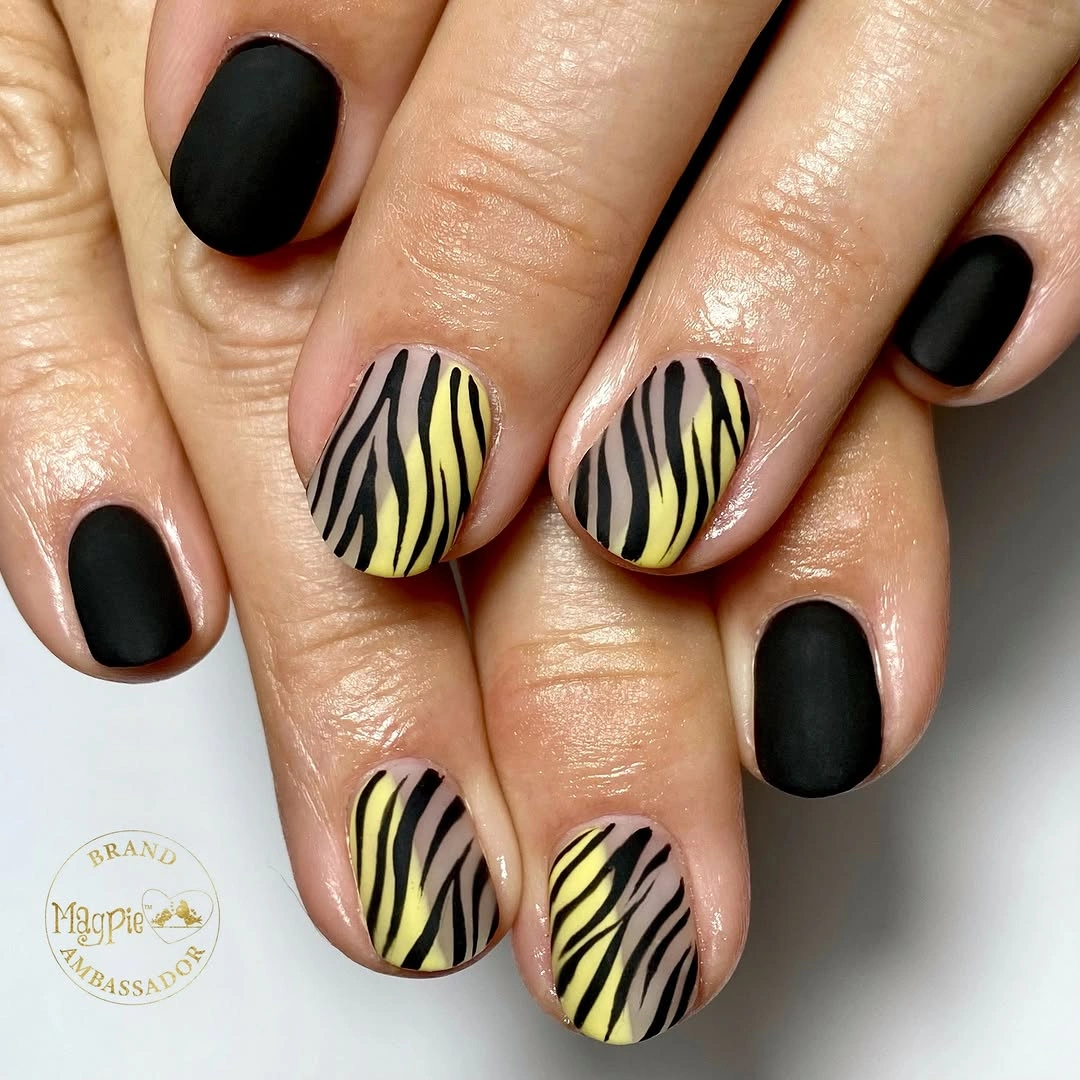 Short rounded black nails with mustard curved stripe accents
