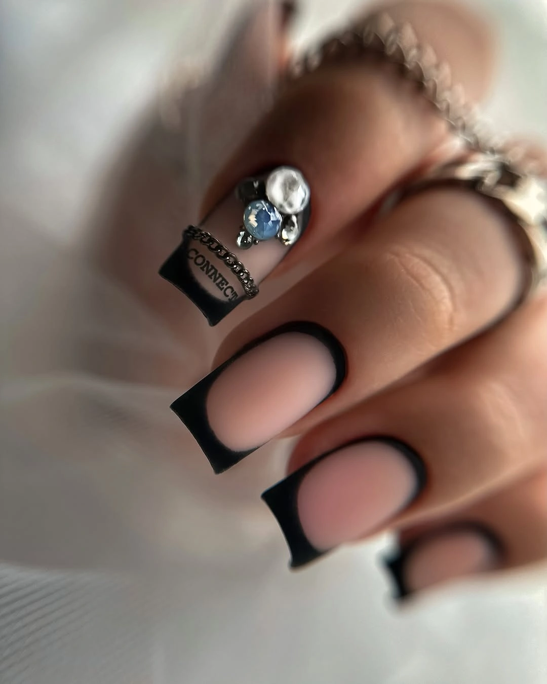 Medium square nails with soft pink centers and black framing
