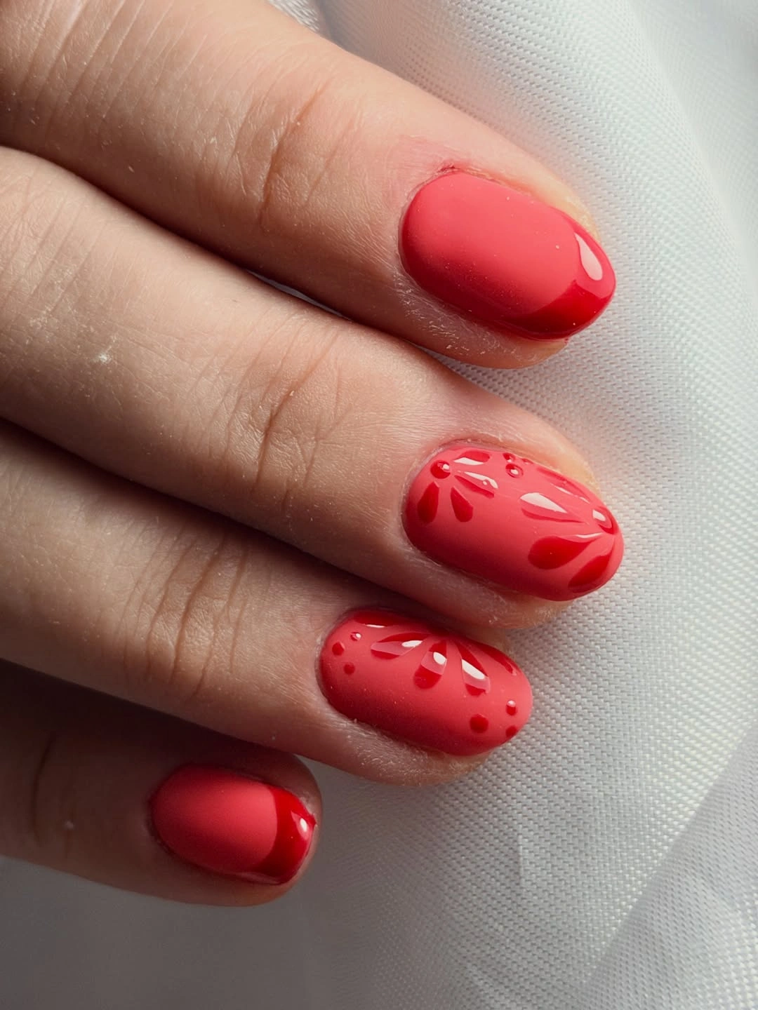 Short red rounded nails with subtle tone-on-tone dotted texture