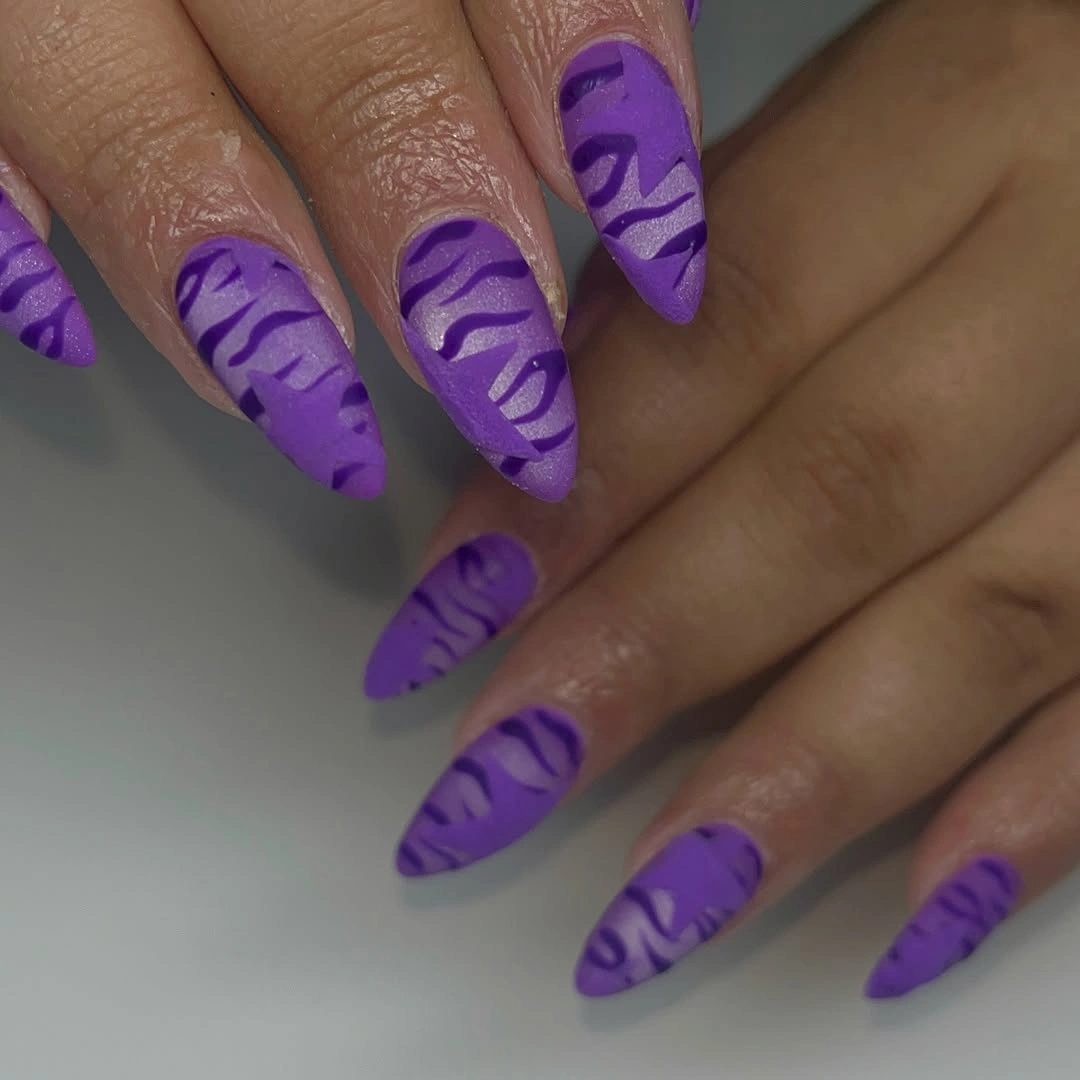 Long purple nails with darker irregular wave stripes