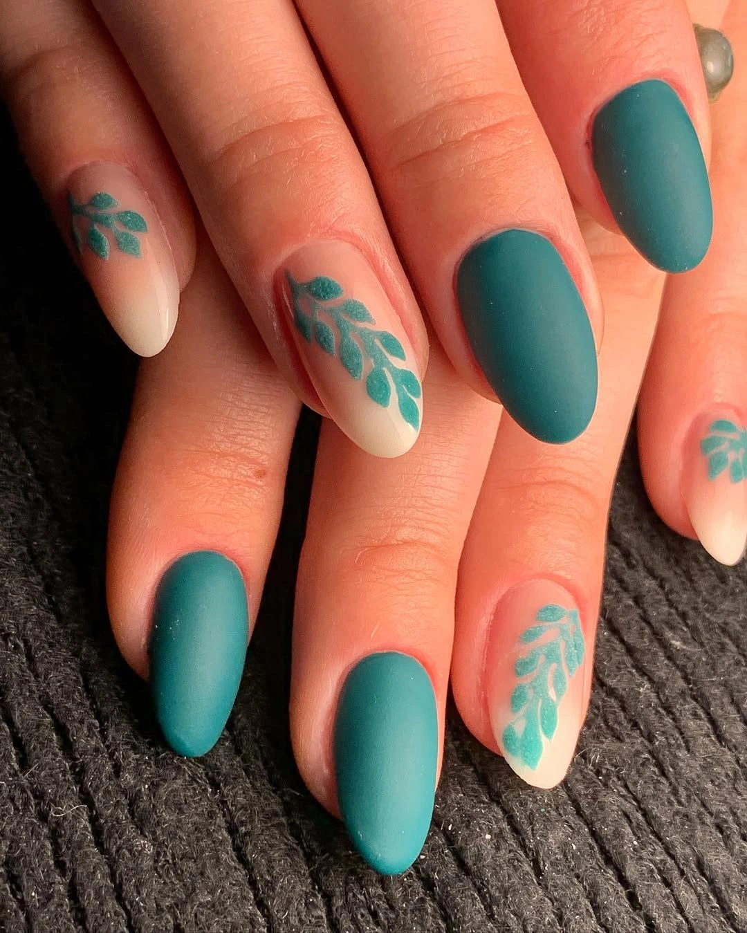 Deep teal nails with pale turquoise botanical accents