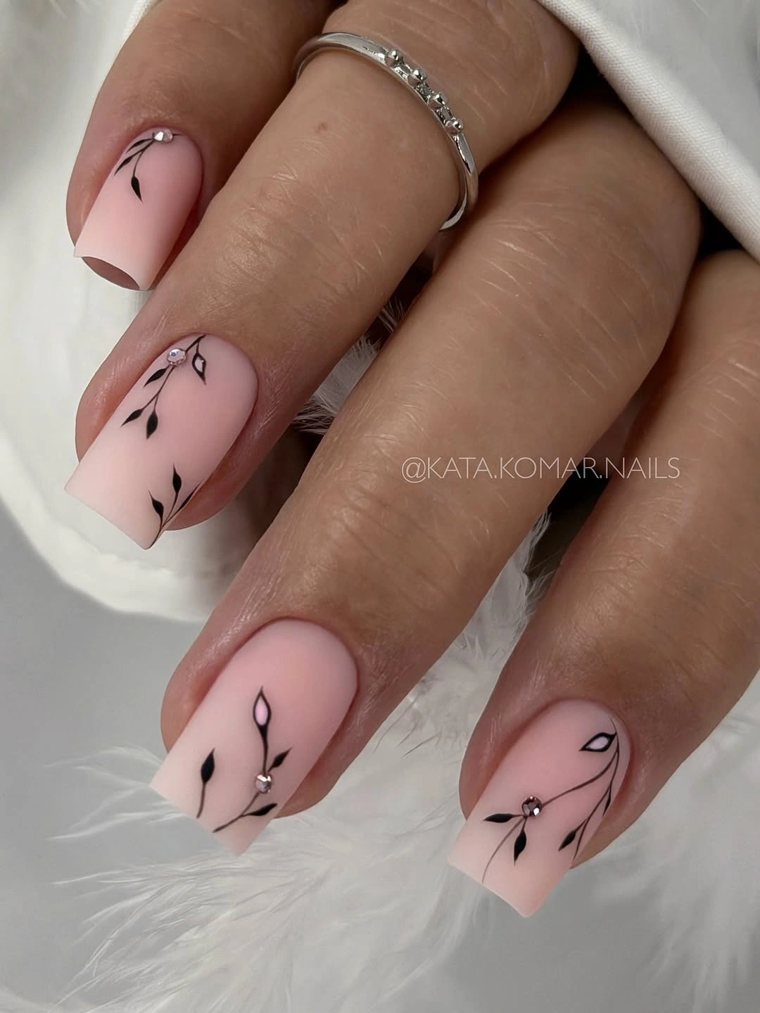 Pale almond nails with minimal black botanical stem lines