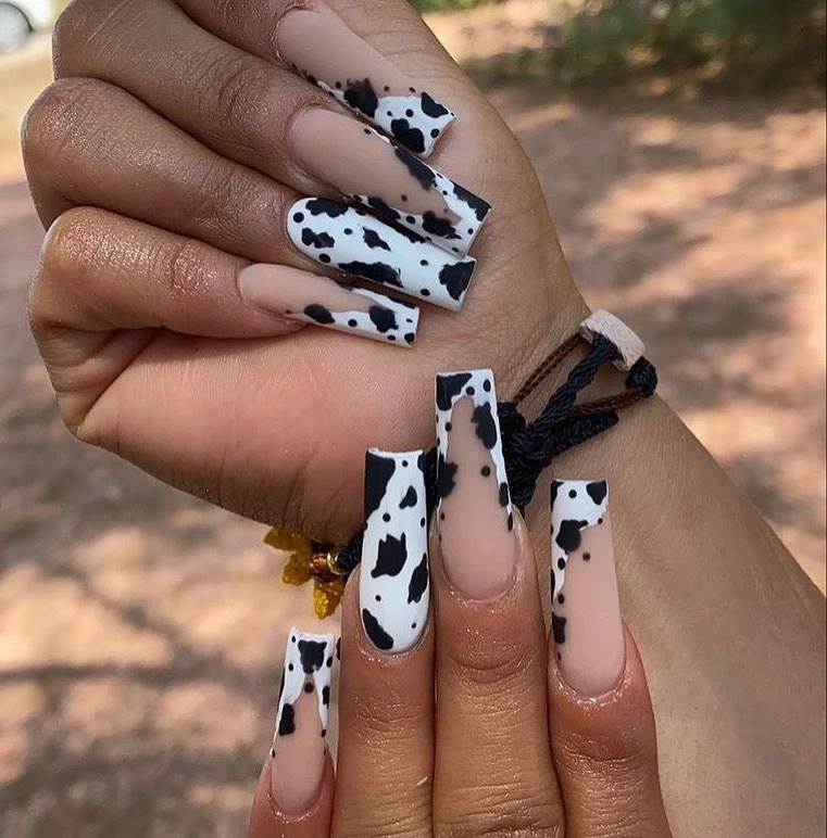 Long pale pink nails with irregular black and white spot accents