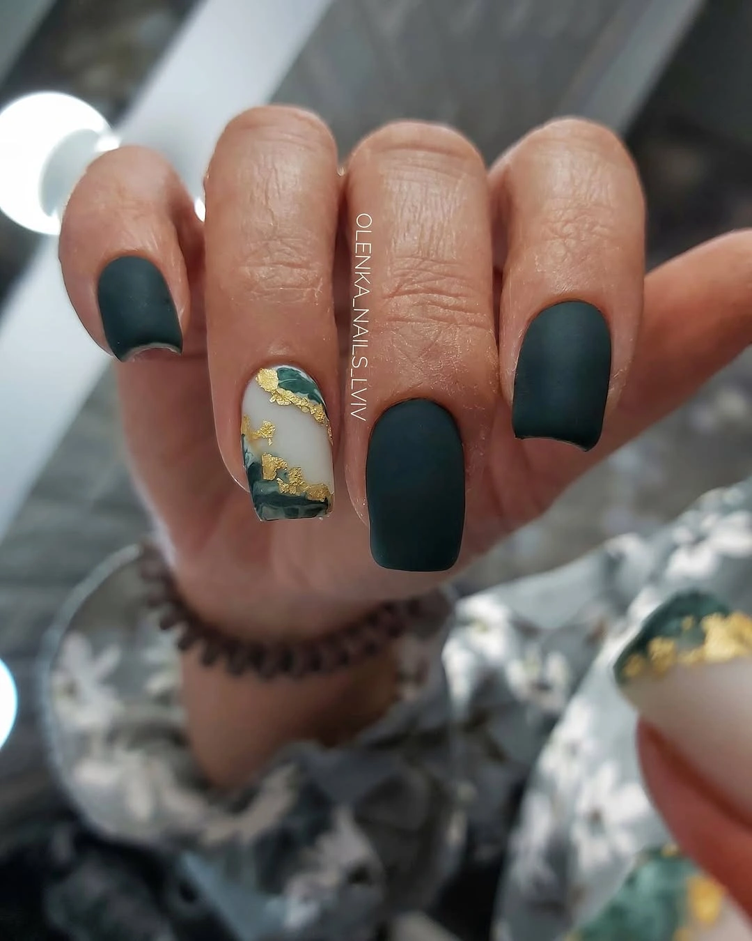 Short forest teal nails with one bright irregular accent patch