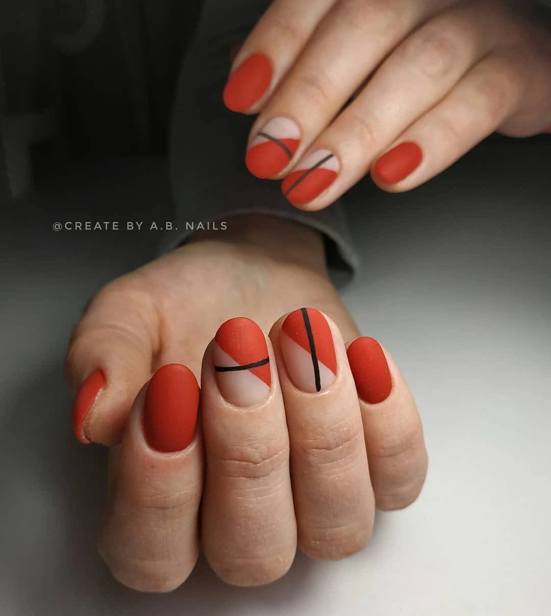 Short rounded coral nails with pale graphic line accents