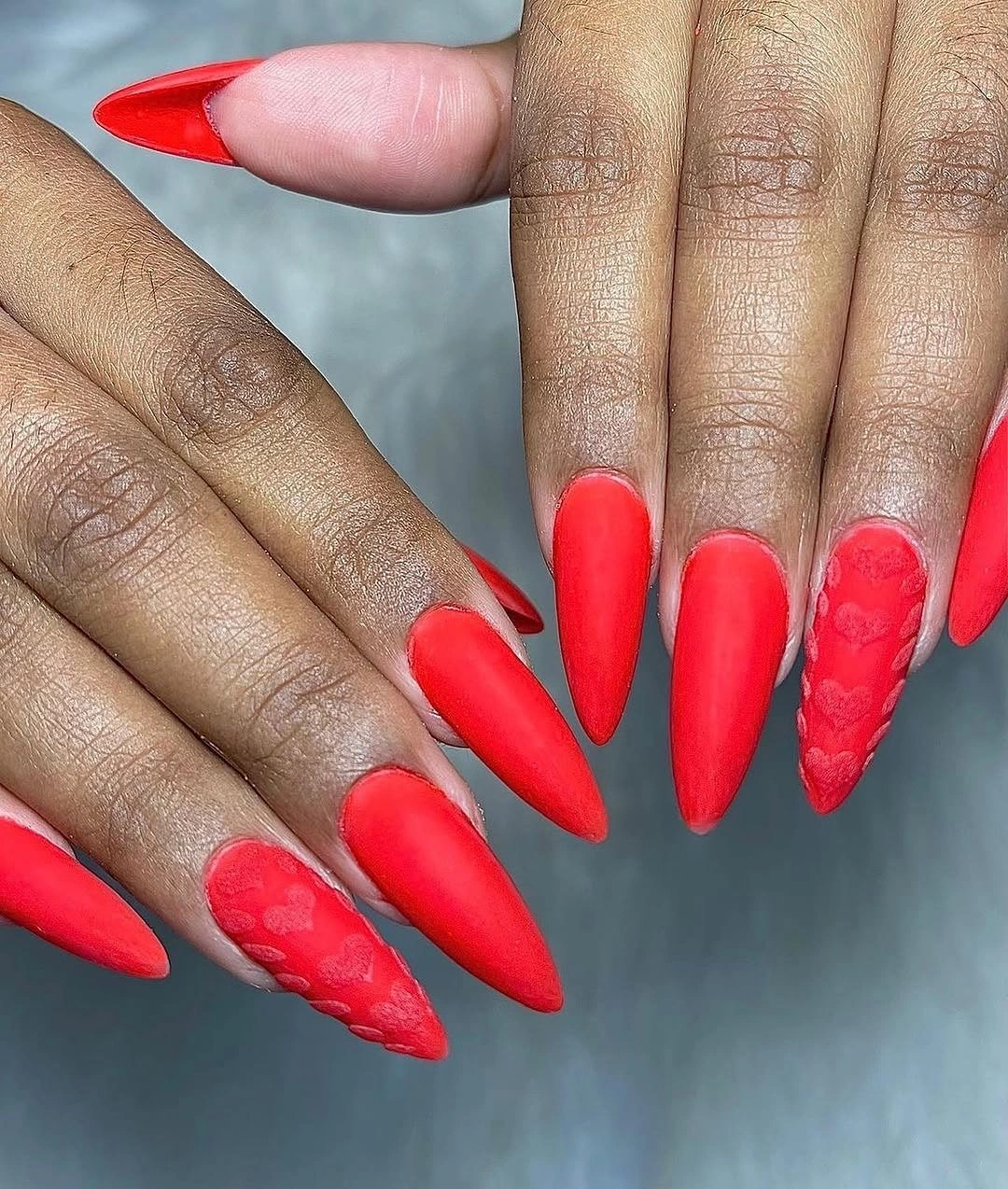 Long vivid red stiletto nails with tonal textured accents