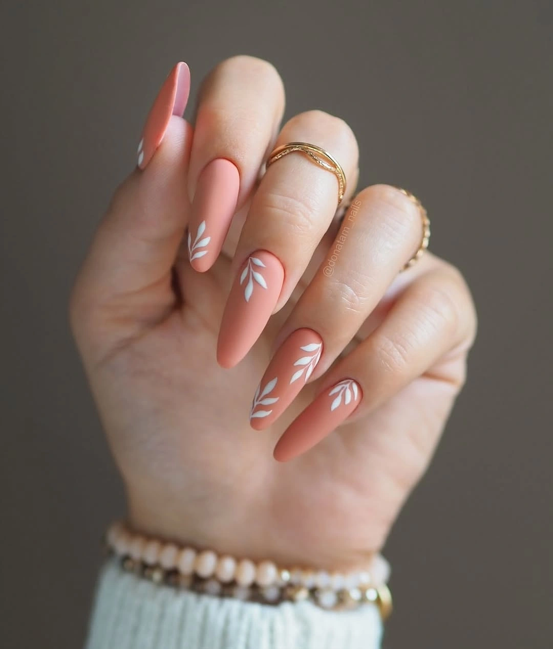Medium coral almond nails with thin white curved stripes