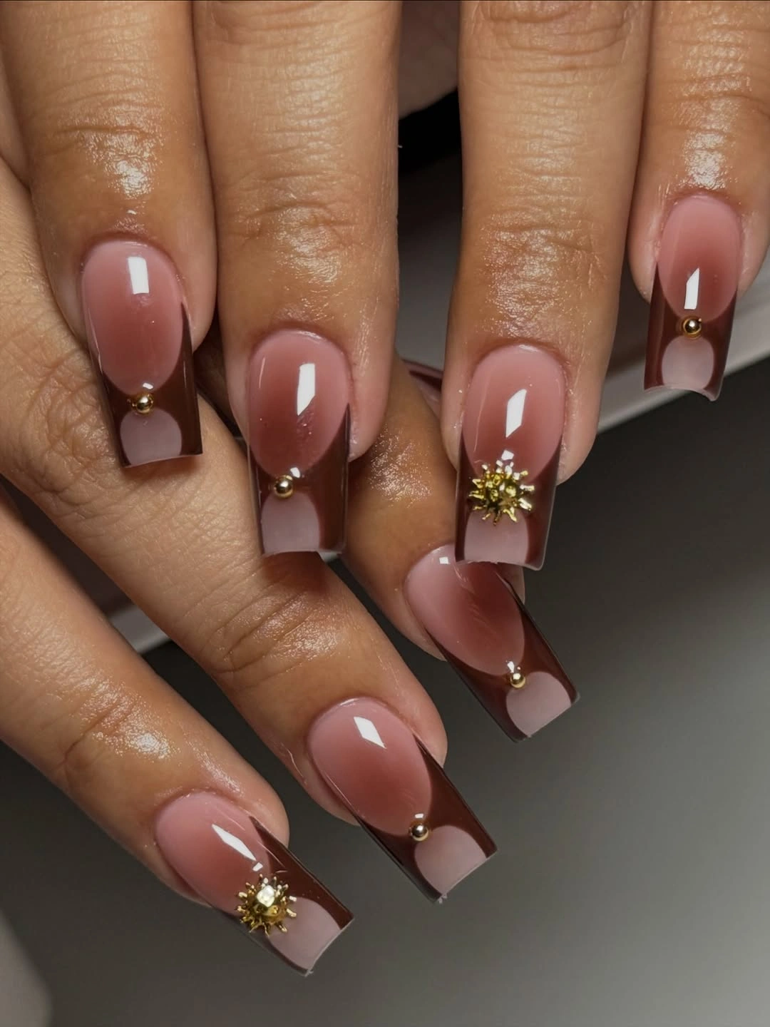 pink nude nails with wine French tips and gold floral accent