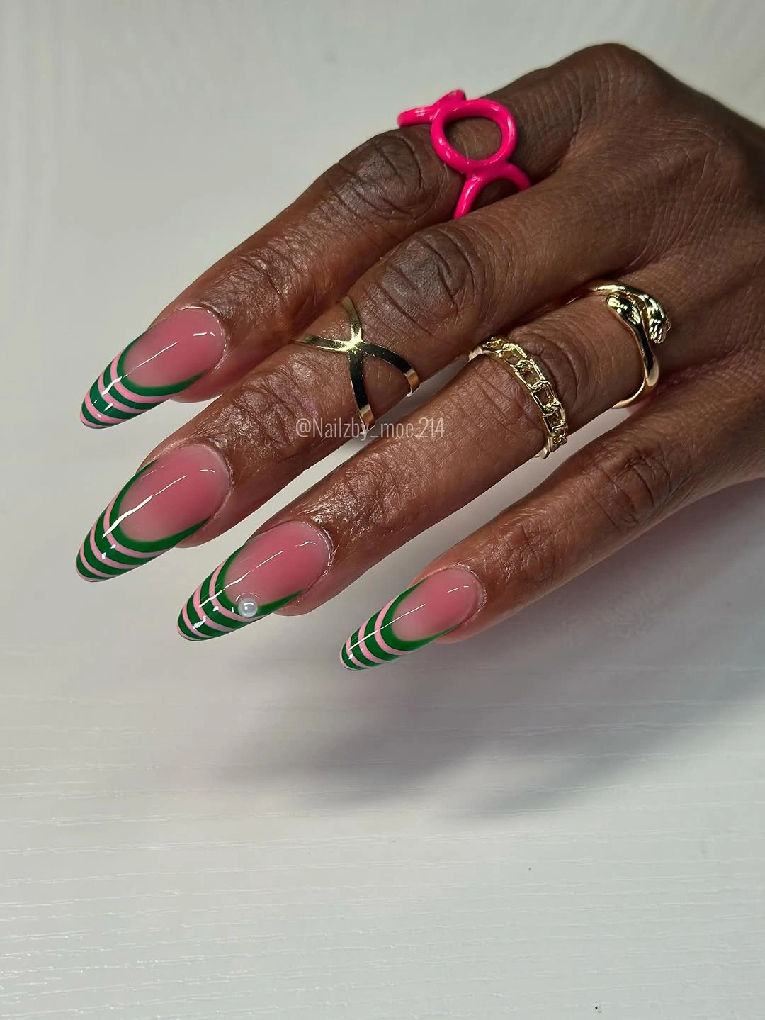 pink almond nails with layered green and white arcs