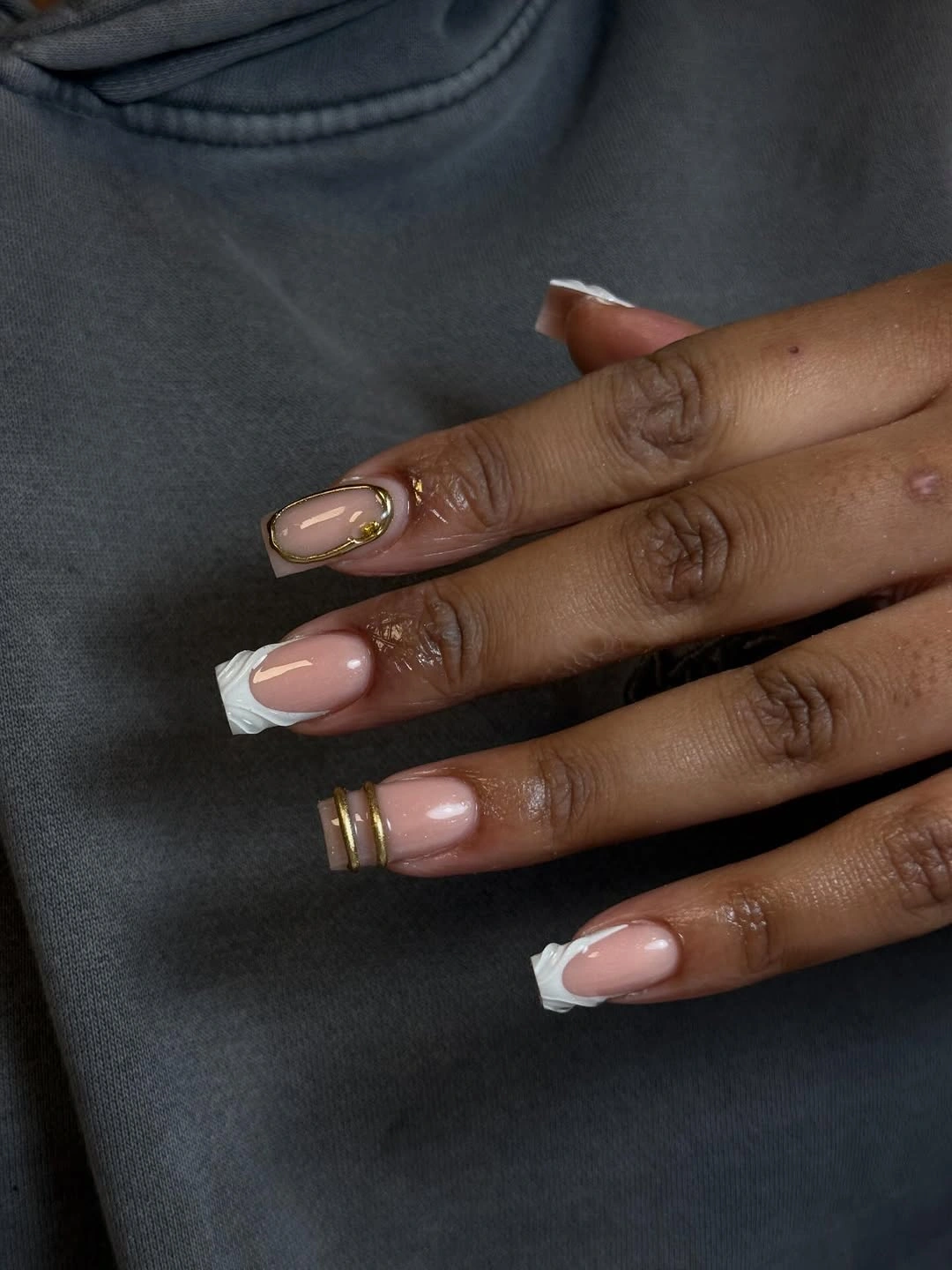 short pink square French nails with one gold outlined accent