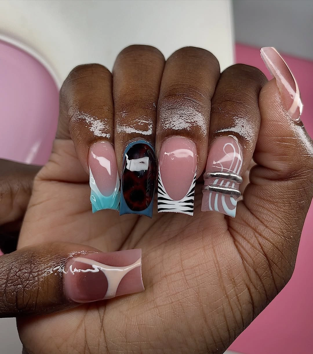 pink nails with turquoise tips, maroon panels, and zebra lines