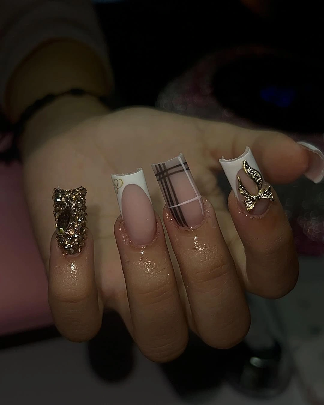 pink nails with dark plaid and dense gold accent details
