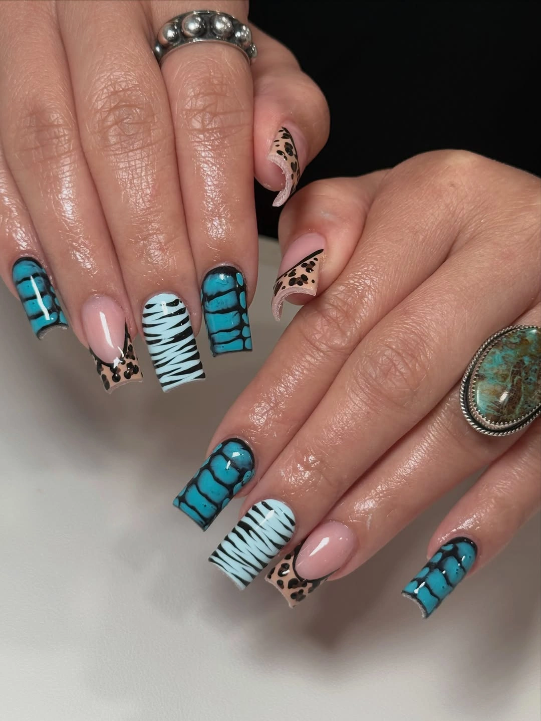 pink square nails with turquoise tips and zebra accents