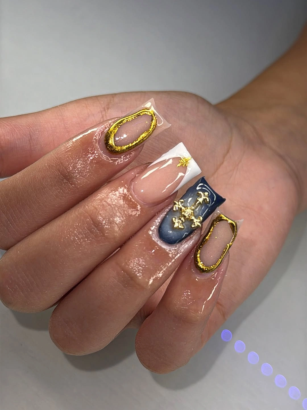 pink square nails with navy accent and thin gold outlines