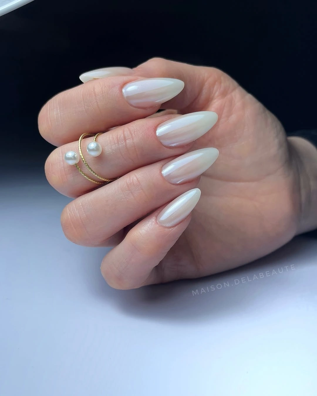 Pearly ivory medium almond nails with glossy sheen