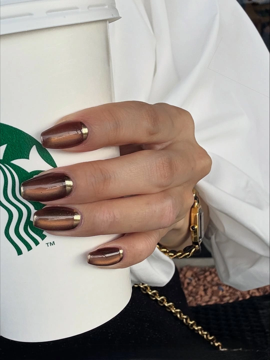 Reflective brown rounded-square nails with tiny gold tips