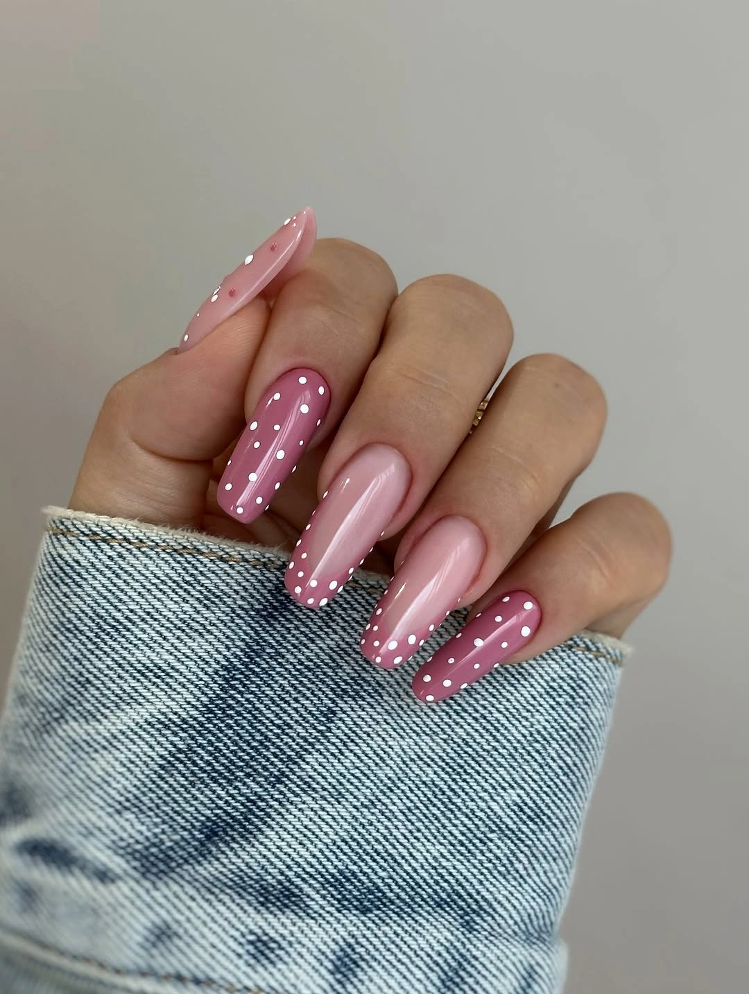 Pink almond nails with white polka dots and plain centers
