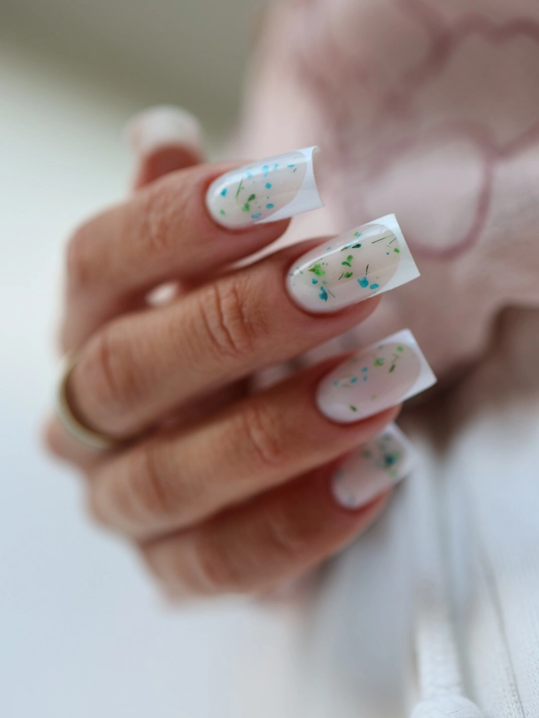 White square nails with sheer centers and blue-green flecks