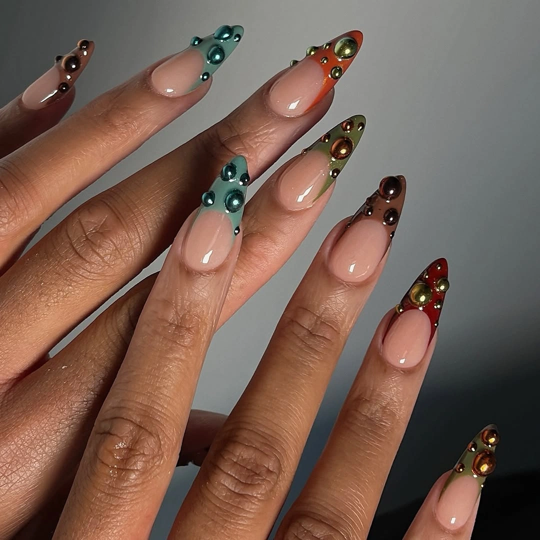 Long pointed nude nails with teal brown red orange and reflective accents