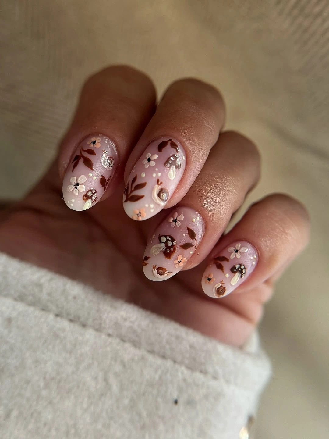 Pale pink rounded square nails with tiny warm floral clusters