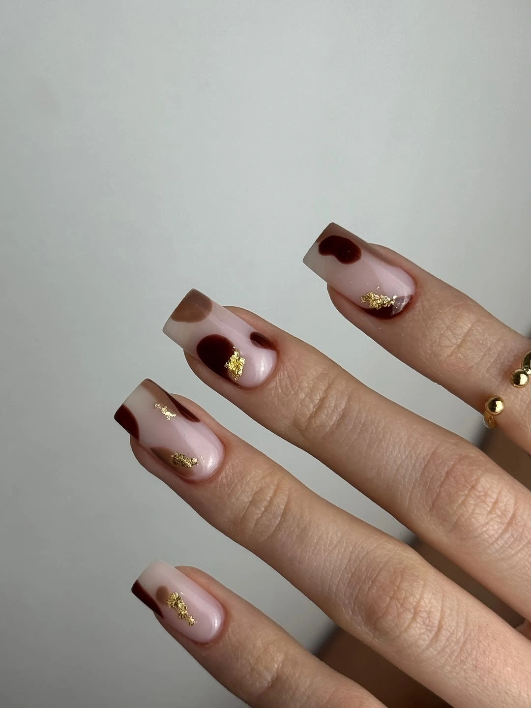 Medium square pink nails with chocolate angular tips and gold details