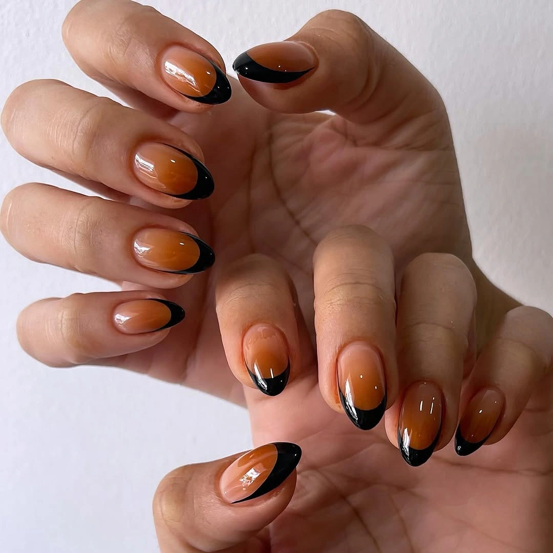 Medium oval nails with translucent amber centers and black tips