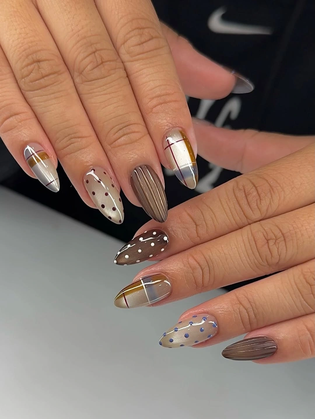 Mismatched medium nails with neutral tips silver gold and dotted accents