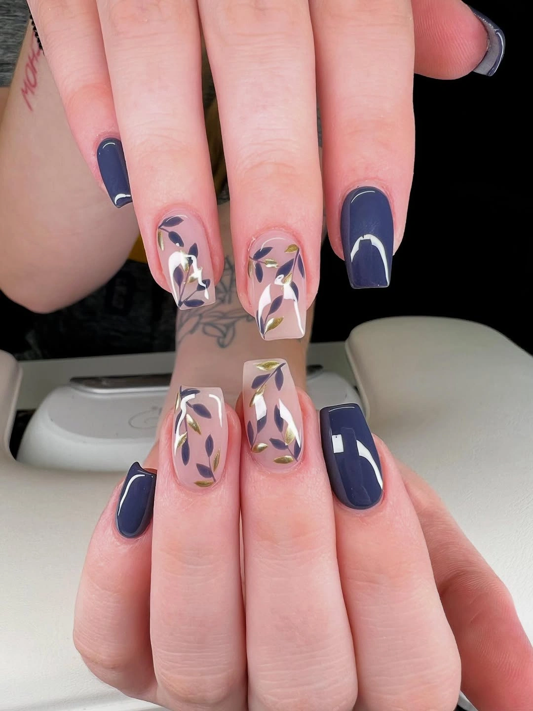 Short square nails with navy solids and pale blue abstract details
