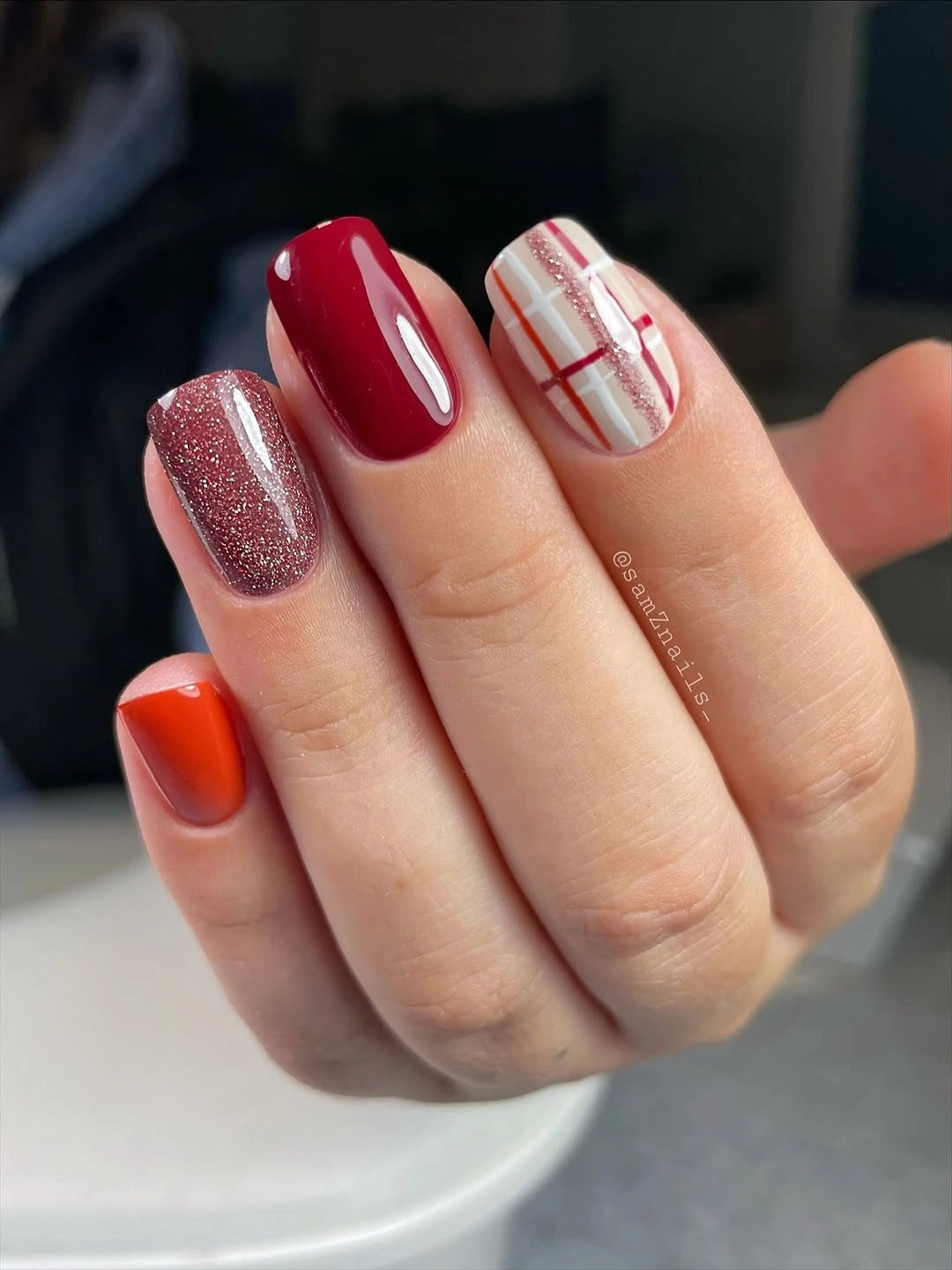 Short red plaid nails with rose glitter accent