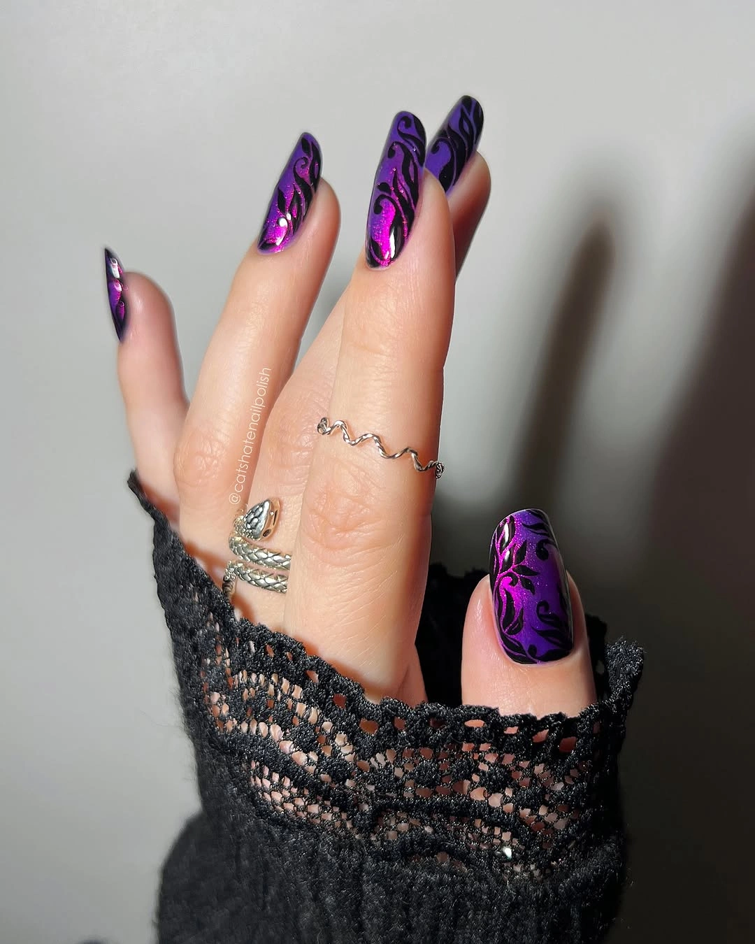 Purple metallic almond nails with black scrollwork