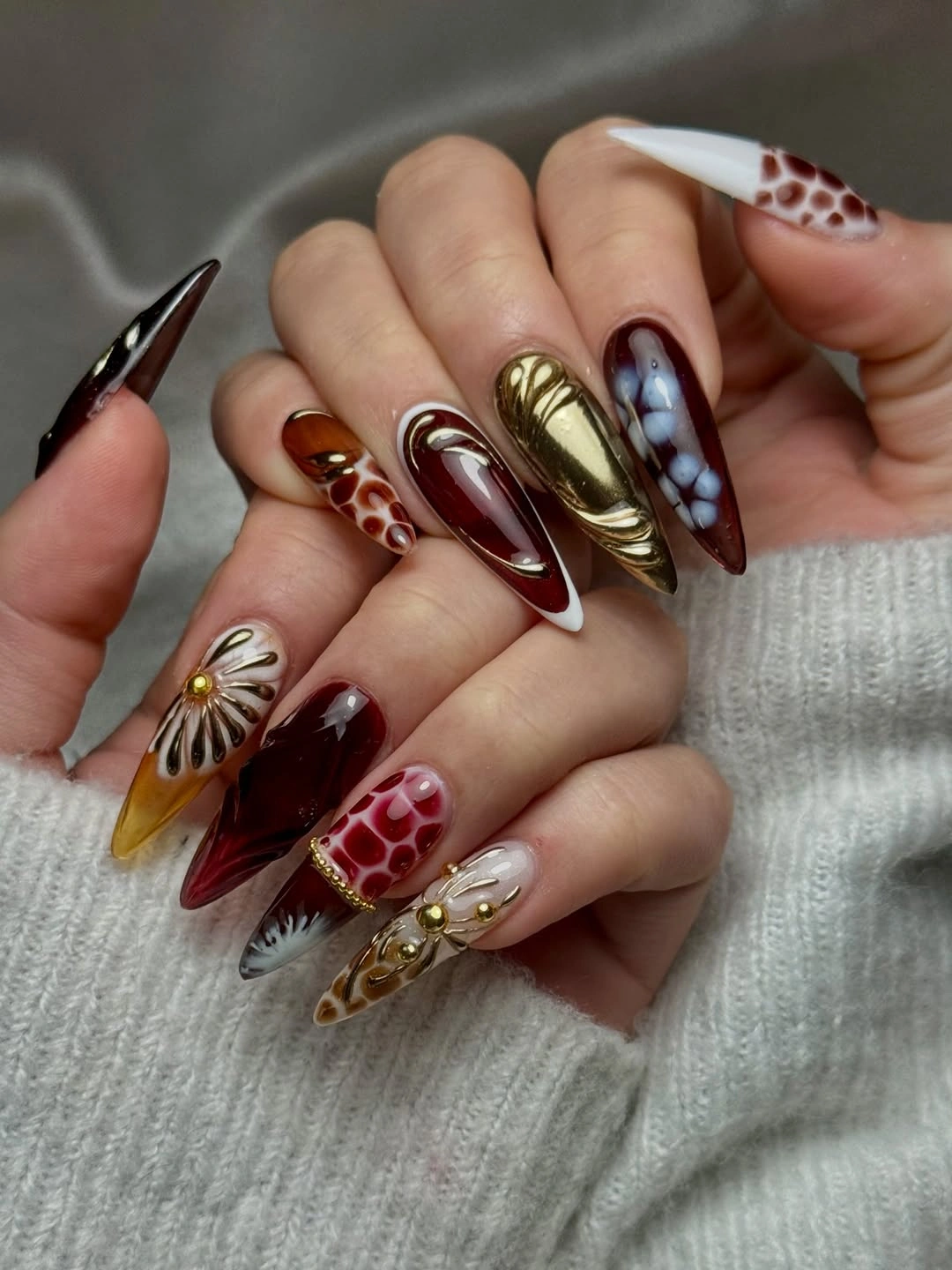 Burgundy stiletto nails with gold and floral details