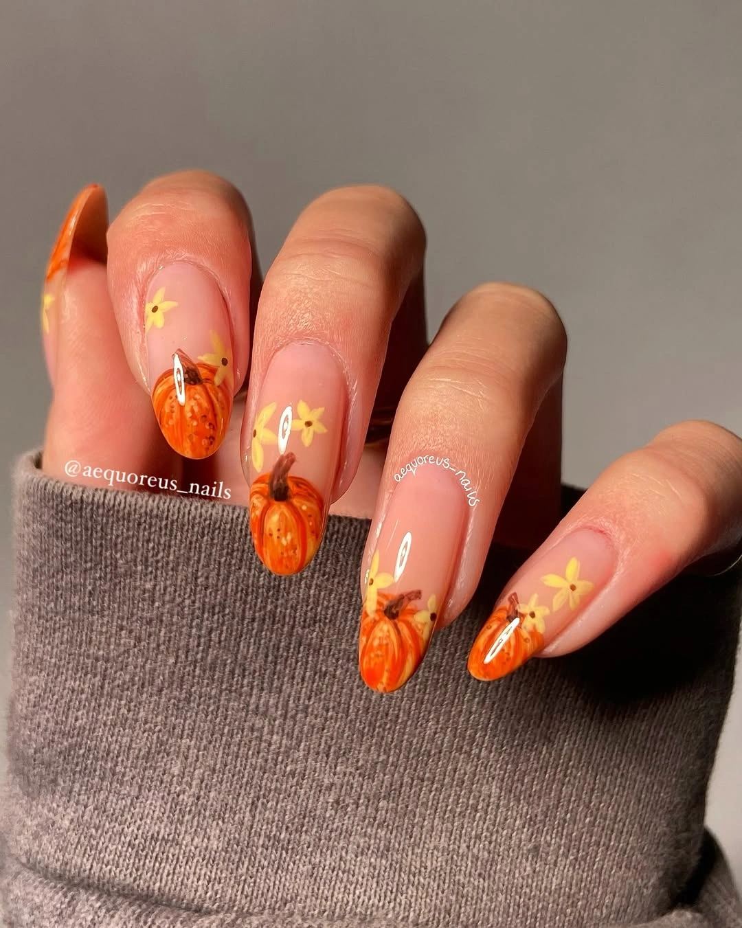 Almond nails with pumpkin tips and yellow flowers