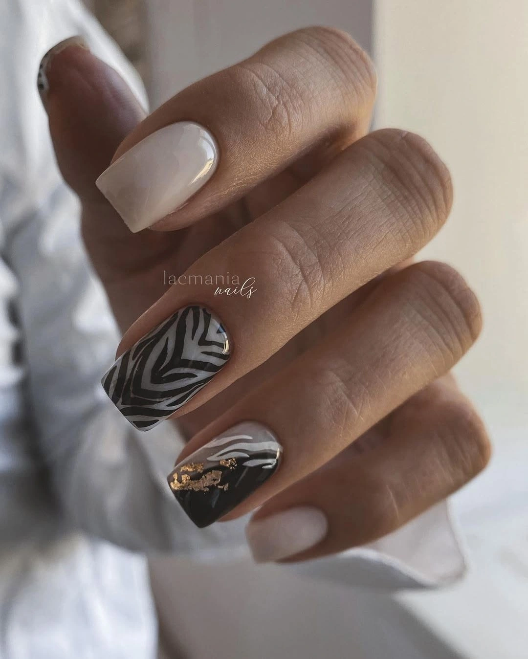 Nude square nails with flowing black gray stripes and gold foil