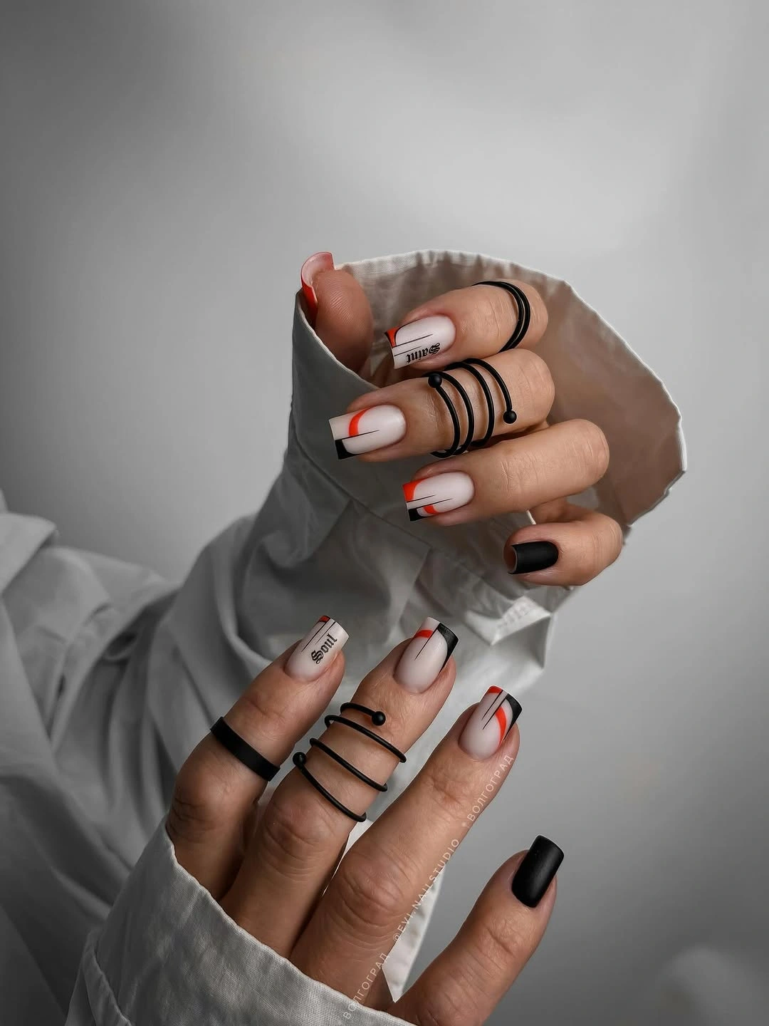 Pale square nails with red and black French tip lines