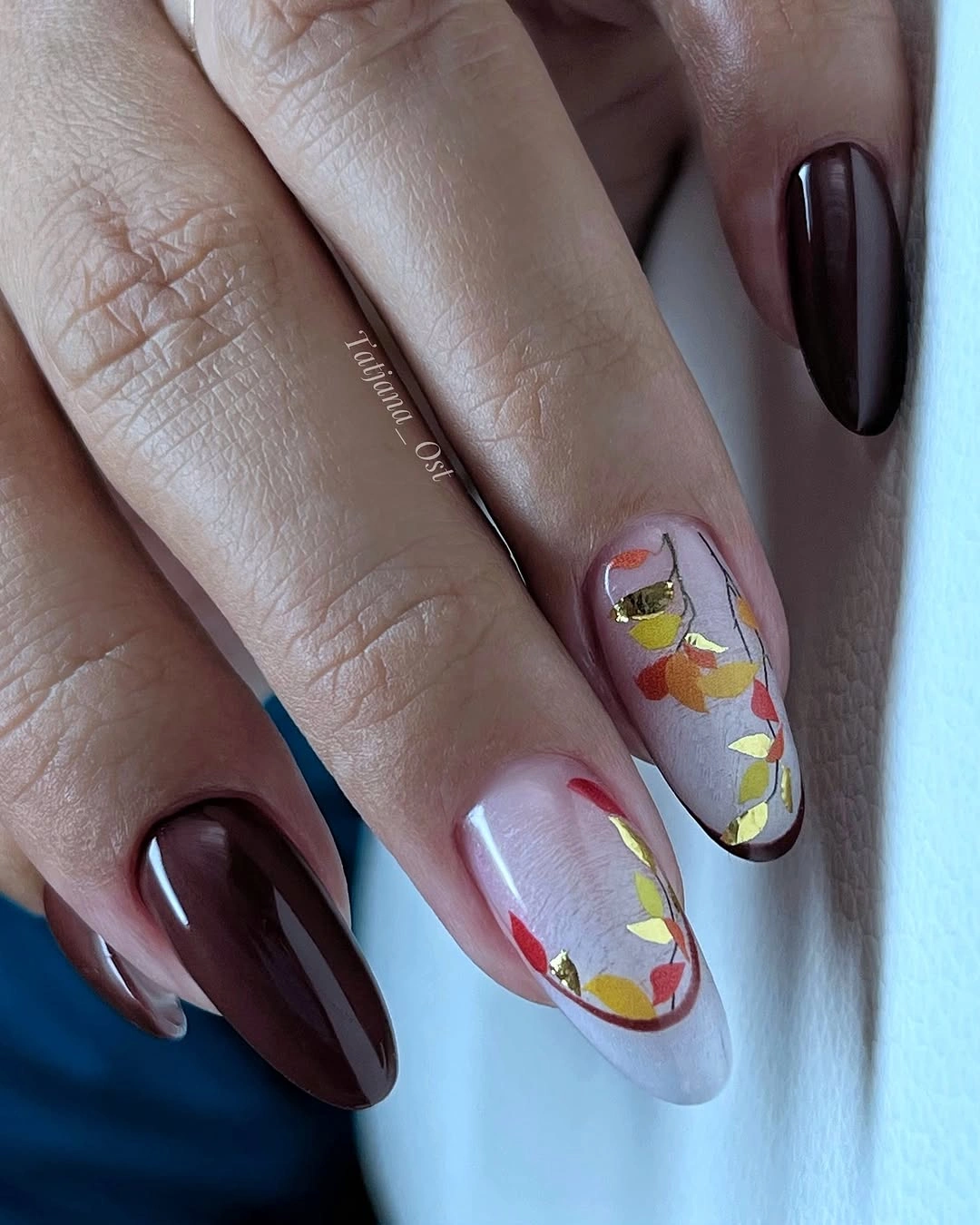 Long burgundy almond nails with pale botanical autumn accents