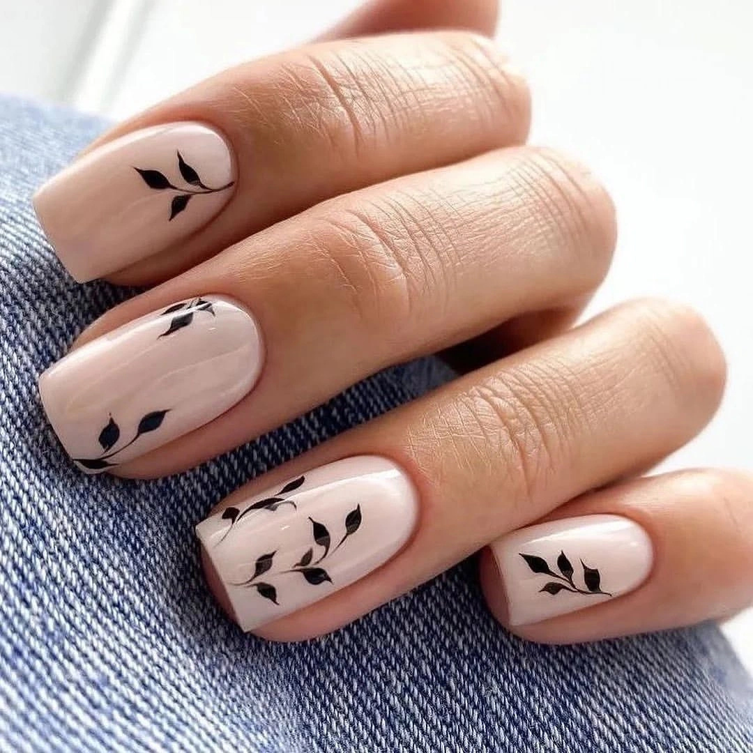 Short nude square nails with small black botanical silhouettes
