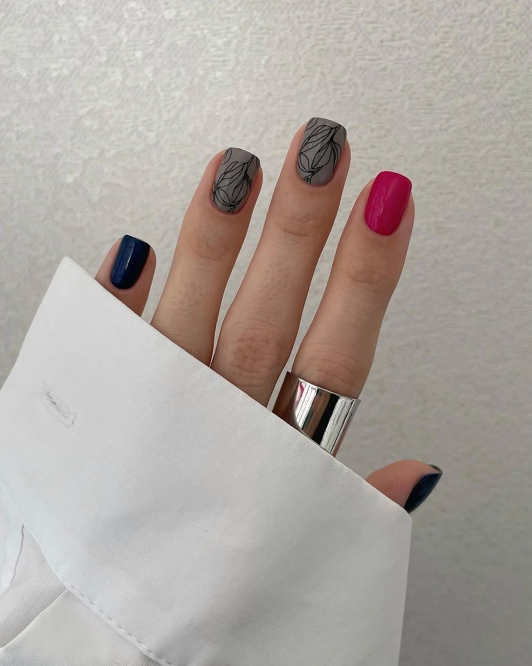 Medium jewel tone nails with pale bases and black leaf outlines