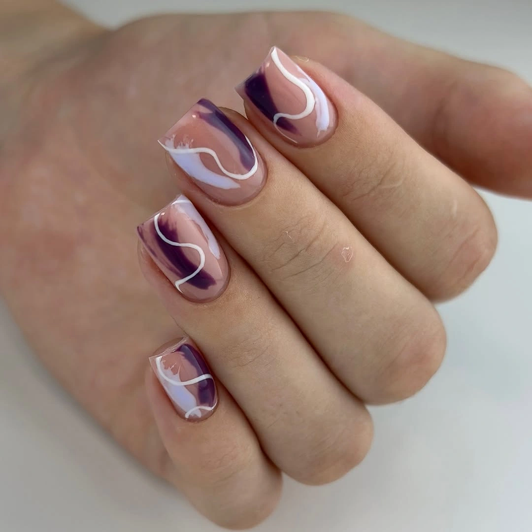Medium oval nails with purple panels and white looping accents