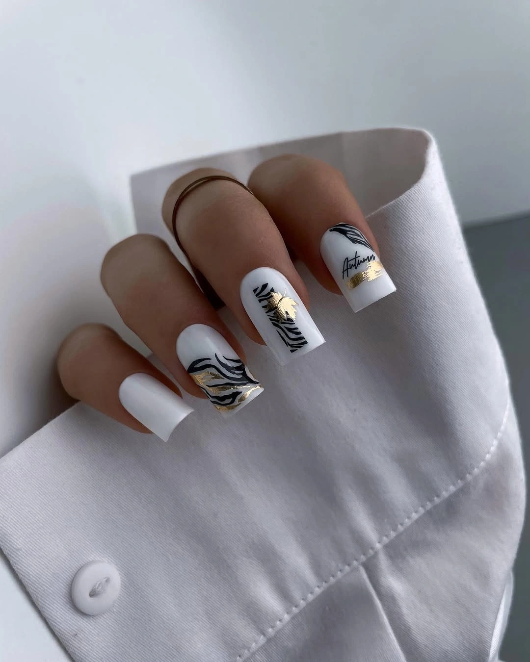 Long white square nails with black botanical and gold line details