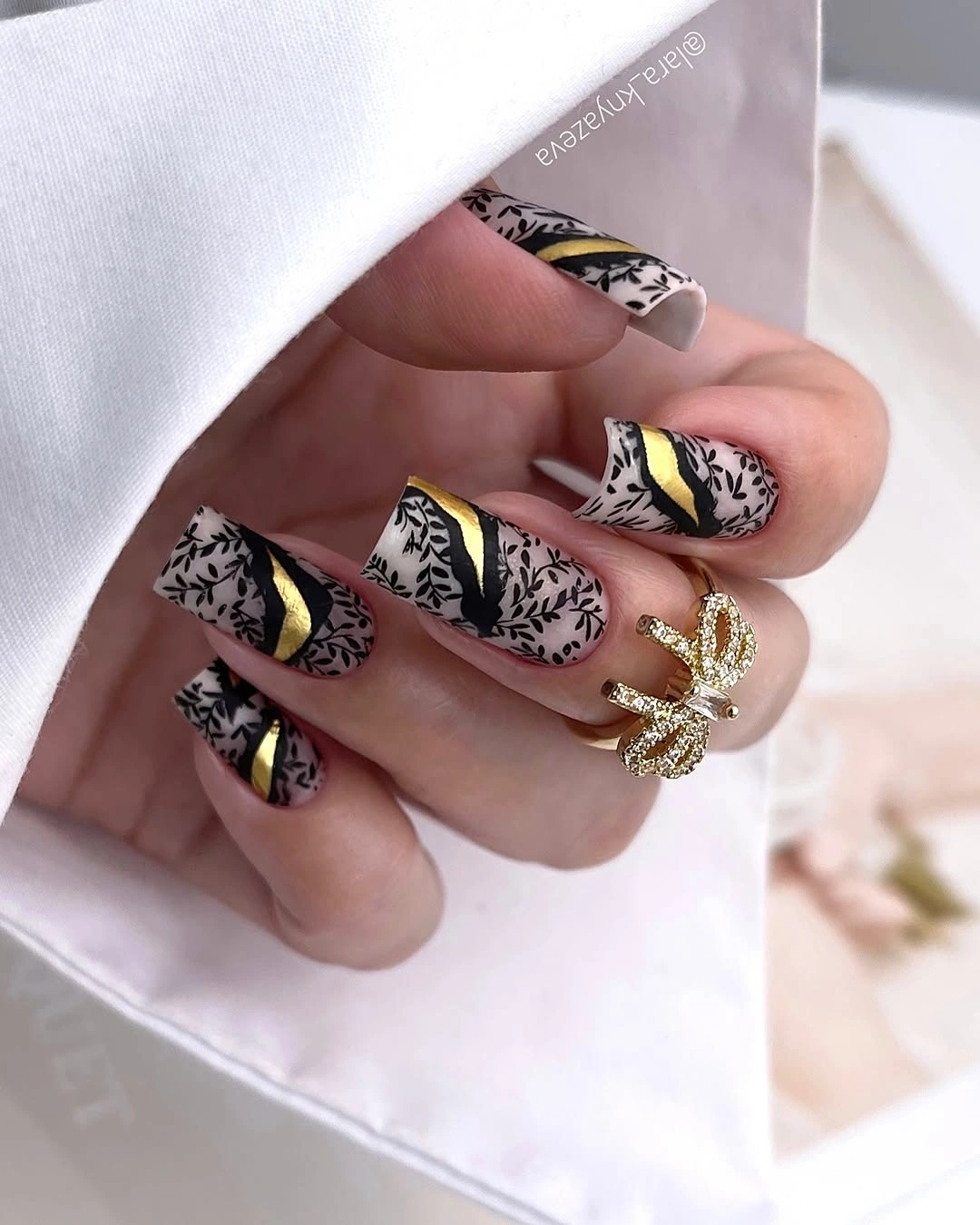 Long square pale nails with black botanical print and yellow accents
