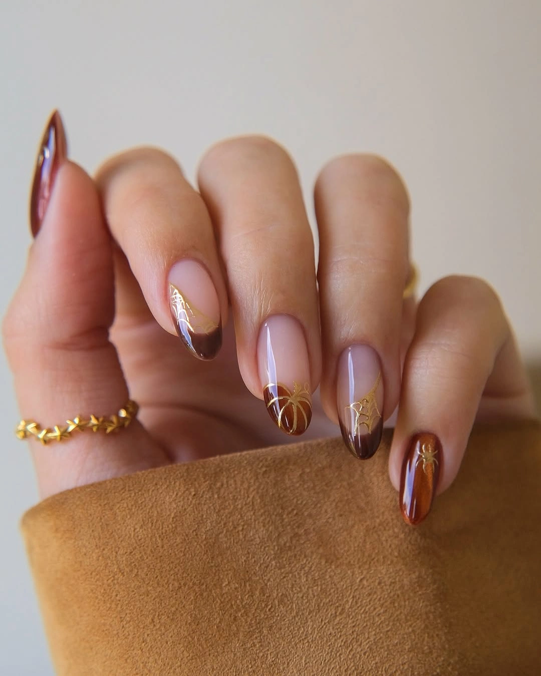 Sheer almond nails with amber tips and web lines